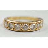 A modern 18ct gold and seven stone diamond set half hoop ring, size P, gross weight 5.3 grams.