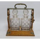 An Edwardian two bottle oak tantalus, 17cms wide