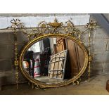 An Edwardian Sheraton revival oval giltwood and composition wall mirror in need of restoration,