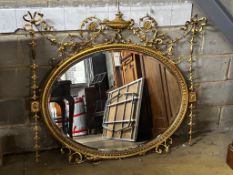 An Edwardian Sheraton revival oval giltwood and composition wall mirror in need of restoration,