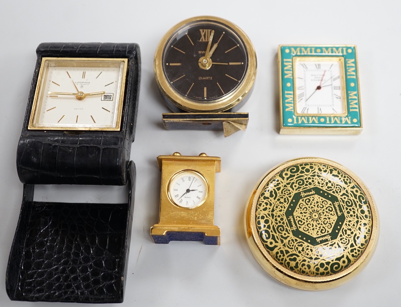 A Halcyon Days Harrods paperweight, a Halcyon Days timepiece and three other timepieces