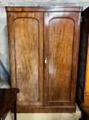 A Victorian mahogany wardrobe, enclosed by a pair of arched panelled full length doors, width 132cm,