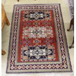 A Caucasian style brick red ground rug, 180 x 128cm