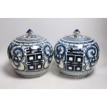 A pair of Chinese blue and white ‘Shuangxi’ jars and cover, 25cms high