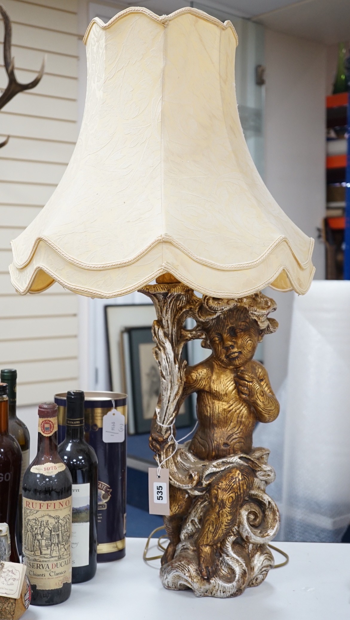 A gilt composition putti table lamp. 86cm tall