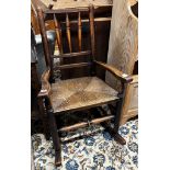 An early 19th century ash rush seat spindle back rocking chair, width 60cm, depth 46cm, height 94cm