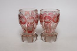 A pair of late 19th century Bohemian wheel engraved ruby stained glass beakers, 13.5cms high
