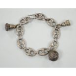 A white metal oval link bracelet, hung with three charms, including two fob seals, 21cm.