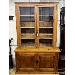 A 19th century French provincial pine two door glazed bookcase, length 151cm, depth 39cm, height