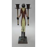 A painted iron novelty two branch monkey candlestick, 44cms high