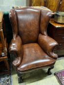A George II style studded brown leather wing armchair, width 84cm, depth 86cm, height 108cm