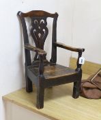 An 18th century pine and fruitwood child's elbow chair, 61cms high (feet spliced)