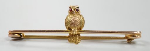 A mid 20th century two colour 9ct owl bar brooch, with cabochon eyes, 38mm, gross weight 1.3 grams.