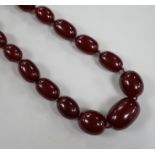 A single strand graduated simulated cherry amber necklace, 82cm, gross weight 83 grams.