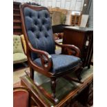 A Victorian carved mahogany upholstered rocking elbow chair, width 53cm, depth 76cm, height 104cm