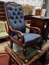 A Victorian carved mahogany upholstered rocking elbow chair, width 53cm, depth 76cm, height 104cm