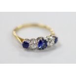 An 18ct, three stone sapphire and two stone diamond set half hoop ring, size P, gross weight 2.7