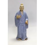 A Chinese glazed pottery figure of a man holding scrolls, early 20th century, 21cm