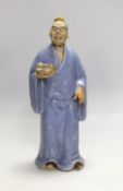 A Chinese glazed pottery figure of a man holding scrolls, early 20th century, 21cm