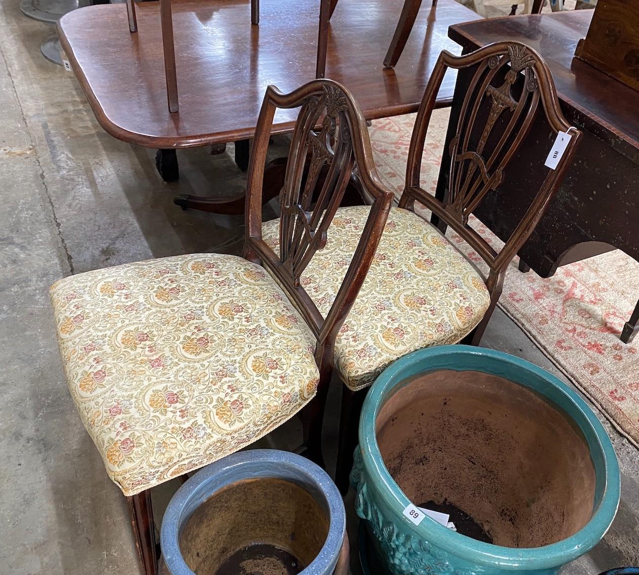 A pair of George III carved mahogany shield back dining chairs