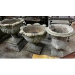 Three circular reconstituted stone garden urns, the largest diameter 48cm, height 55cm