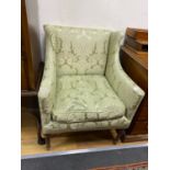 A small Edwardian mahogany upholstered wing armchair, covered in a pale green damask material, width