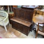 A carved and panelled oak settle incorporating old timber, width 106cm, depth 34cm, height 114cm