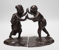 A pair of Japanese Meiji period bronze bookends modelled as a husband and wife pushing against