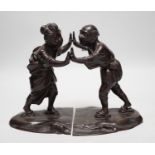 A pair of Japanese Meiji period bronze bookends modelled as a husband and wife pushing against