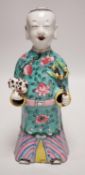 An early 19th century Chinese enamelled porcelain figure of a boy holding a cat and a sprig of