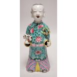 An early 19th century Chinese enamelled porcelain figure of a boy holding a cat and a sprig of