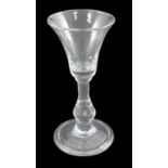 A true baluster wine or cordial glass, c.1720, the bell-shaped bowl above a tear drop baluster stem,