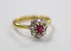 A modern 18ct gold, garnet? and diamond set oval cluster ring, size M, gross weight 3.2 grams.