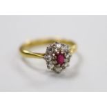 A modern 18ct gold, garnet? and diamond set oval cluster ring, size M, gross weight 3.2 grams.