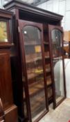 A large mahogany bookcase with two glazed panel doors, width 138cm, depth 31cm, height 209cm