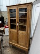 A Victorian glazed pine two door cabinet on stand, width 96cm, depth 27cm, height 182cm