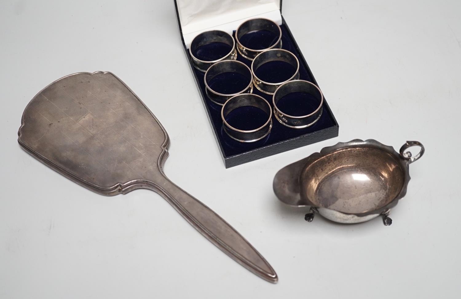 A set of six modern silver napkin rings, a George V silver sauceboat and a silver mounted hand