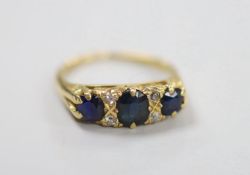 An early to mid 20th century gold, three stone sapphire and four stone diamond chip set half hoop