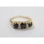 An early to mid 20th century gold, three stone sapphire and four stone diamond chip set half hoop