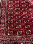 A Bokhara burgundy red ground rug, 180 x 150cm