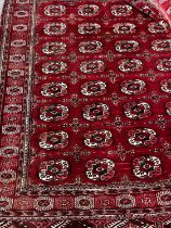 A Bokhara burgundy red ground rug, 180 x 150cm