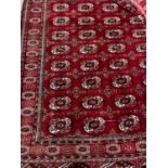 A Bokhara burgundy red ground rug, 180 x 150cm