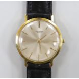 A gentleman's 18ct gold Universal manual wind wrist watch, with baton numerals, on a leather strap