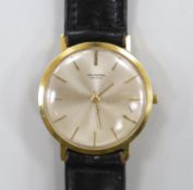 A gentleman's 18ct gold Universal manual wind wrist watch, with baton numerals, on a leather strap