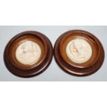 A pair of late 19th century carved and moulded composition portrait roundels, in oak frames