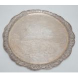 A Chinese Export white metal circular salver with pierced foliate wavy border and engraved with