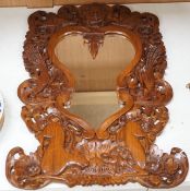 A Balinese carved wood wall mirror, 62cm long