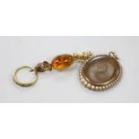 A 19th century yellow metal and split pearl mounted glazed mourning locket pendant containing a lock
