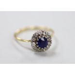 A yellow metal, sapphire and diamond set oval cluster ring, size Q, gross weight 2.8 grams.
