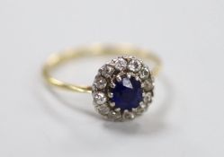 A yellow metal, sapphire and diamond set oval cluster ring, size Q, gross weight 2.8 grams.